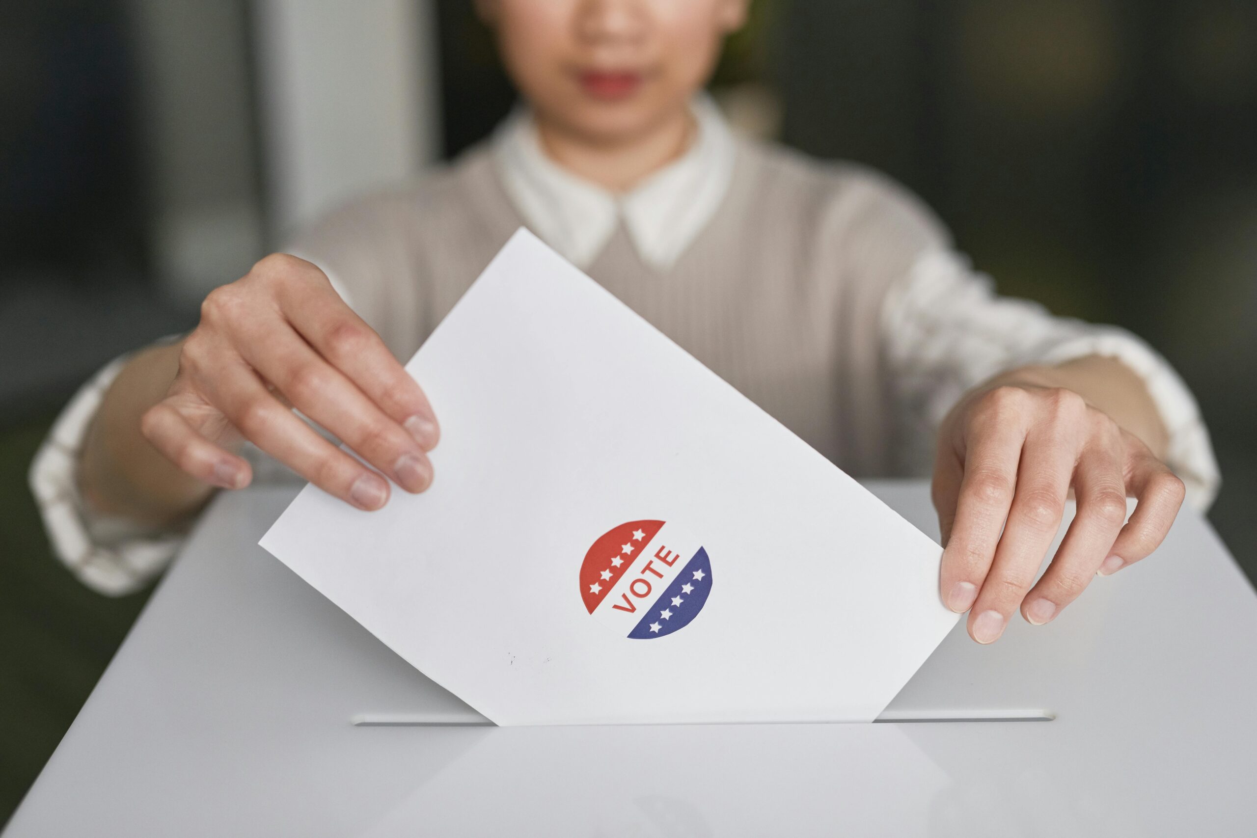 Woman dropping a ballot into a voting box