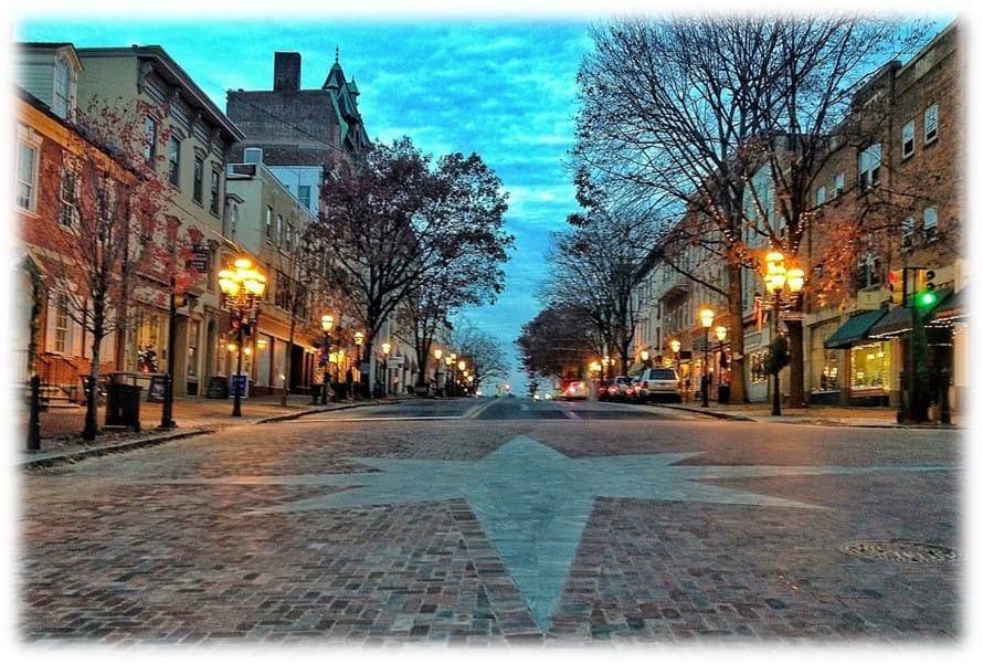 A view down a brick road lined with historic buildings with a Moravian star in the brick work