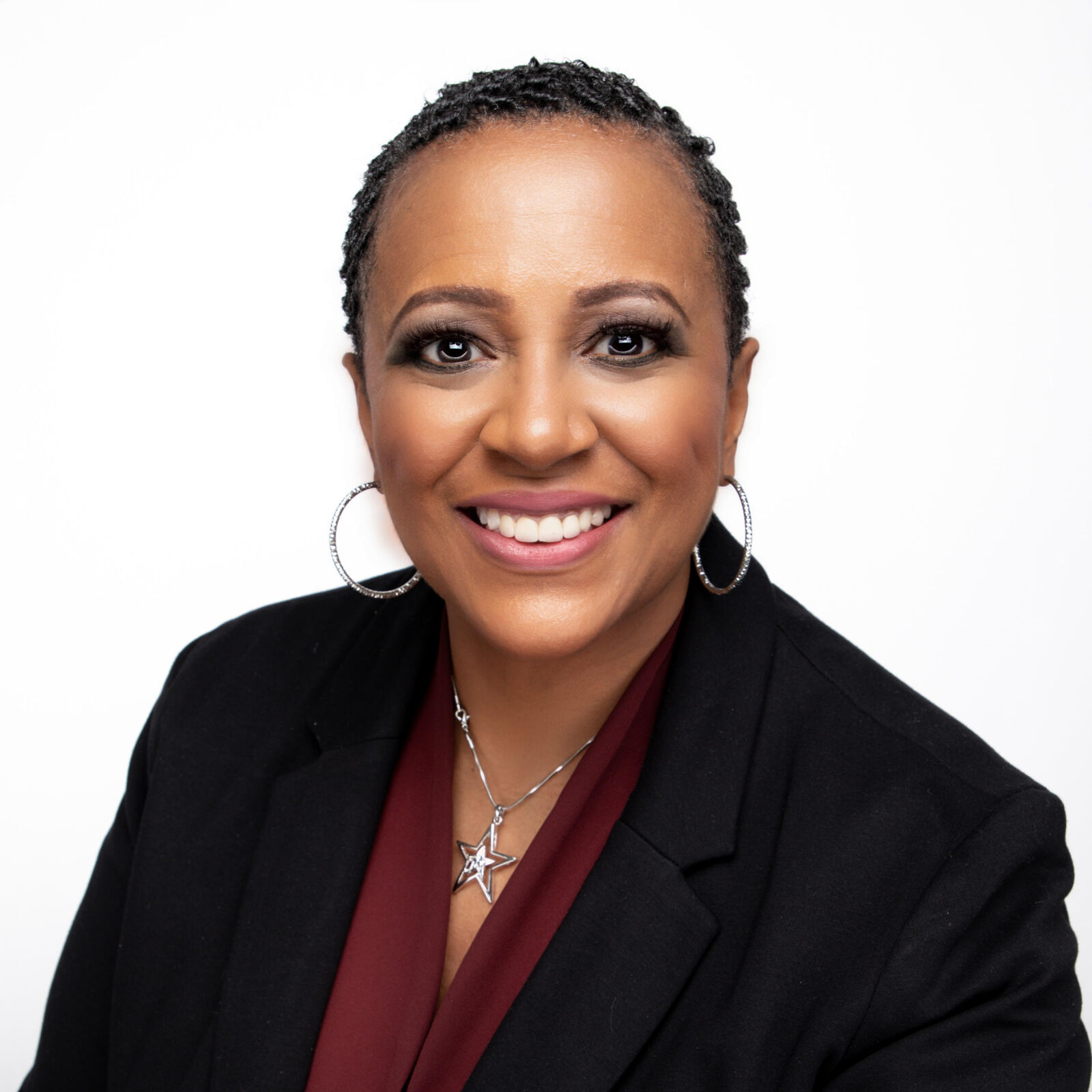 Angela Brooks wearing a black suit and a burgundy colored shirt