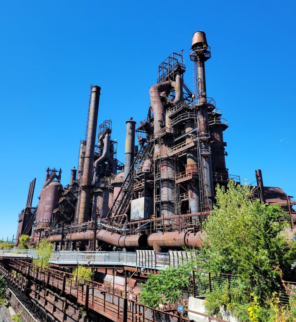 Rusty former steel stacks against a brilliant blue sky