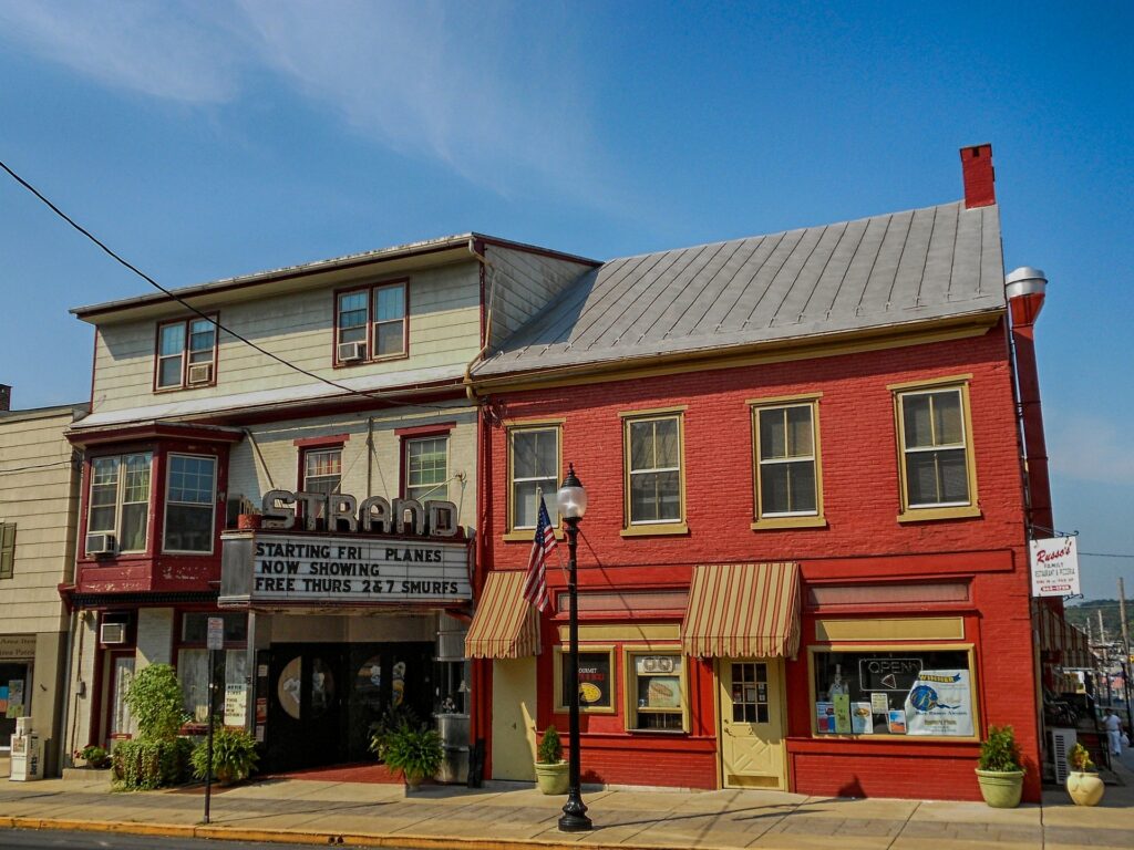 The Strand movie theater with a historic marquee next to a red brick building